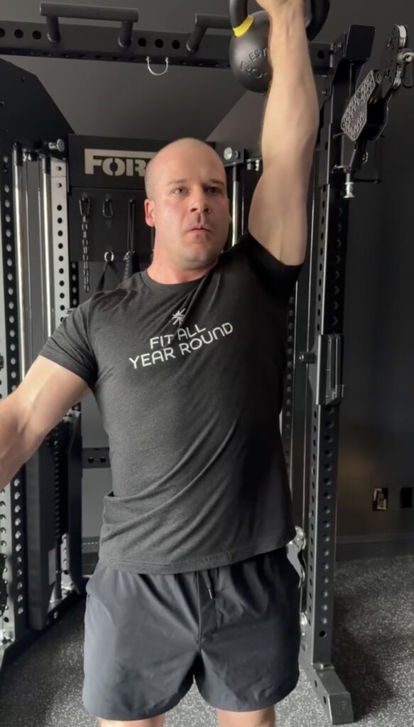 Kettlebell overhead press during strength training at Fit All Year Round in Belmont, MA